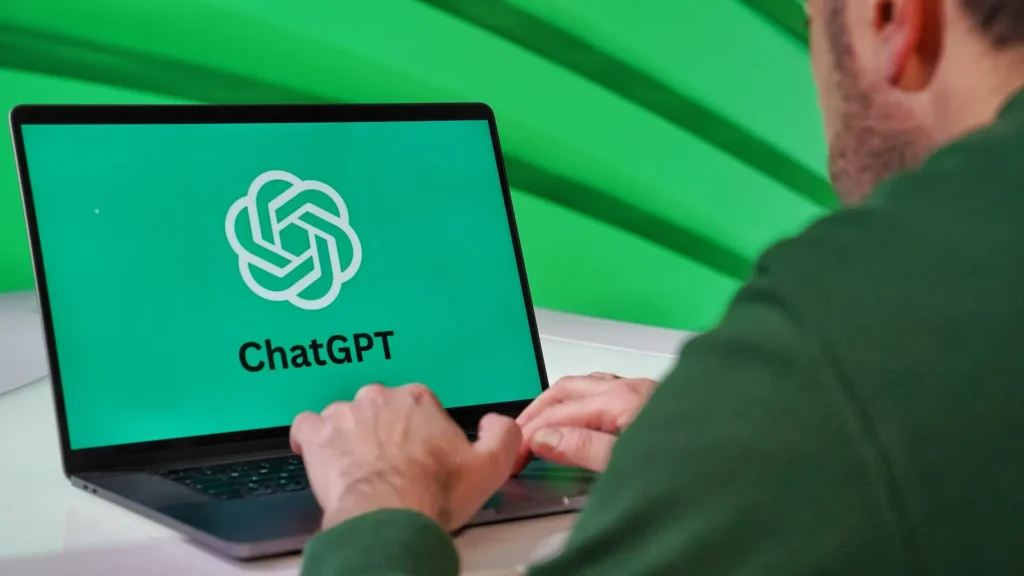 A person at a laptop displaying the ChatGPT logo, against a vivid green background
